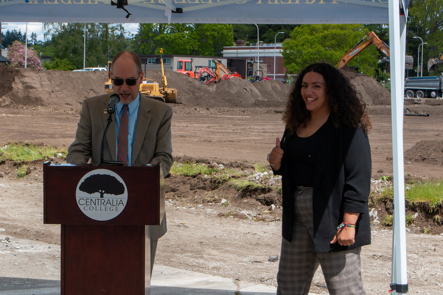 Bob Mohrbacher, Centralia College president, passes off the stand to Marisol Vargas, student body president, for the groundbreaking ceremony of the Centralia College multi-purpose athletic field Wednesday afternoon.